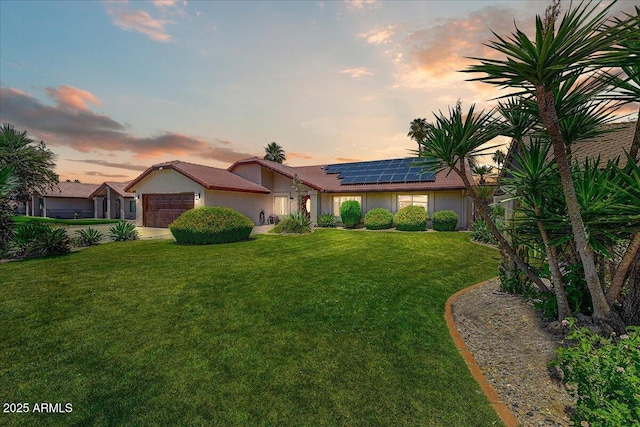 5710 E Anderson Dr, Scottsdale, AZ 85254 - single story home featuring a garage, roof mounted solar panels, a lawn, and stucco siding