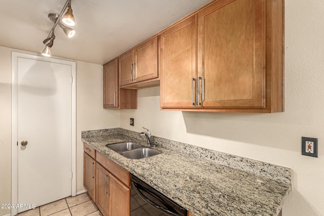 kitchen with light stone counters, black dishwasher, brown cabinets, light tile patterned floors, and a sink