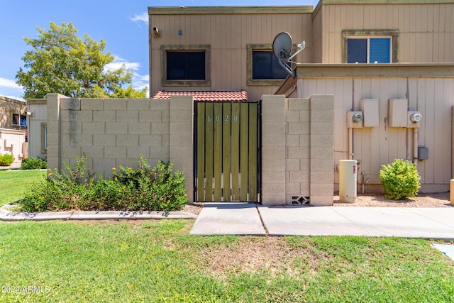 view of front of home featuring a gate, fence, and a front lawn