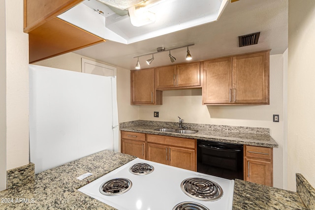 kitchen with white appliances, visible vents, brown cabinetry, light stone counters, and a sink