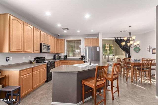 kitchen featuring sink, appliances with stainless steel finishes, a healthy amount of sunlight, and a center island with sink