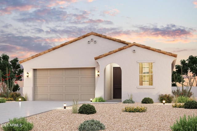 mediterranean / spanish-style home featuring an attached garage, concrete driveway, a tile roof, and stucco siding