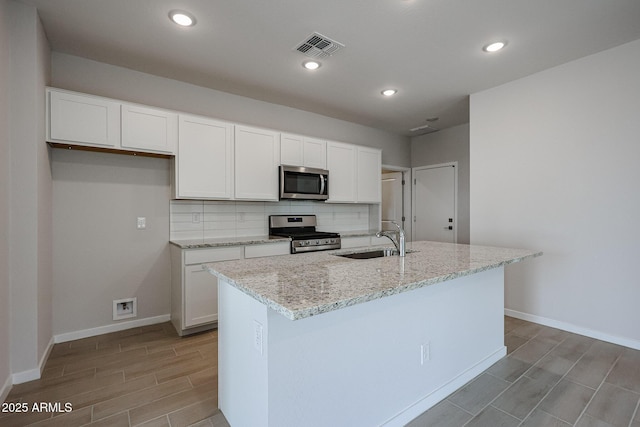 kitchen with a sink, white cabinetry, appliances with stainless steel finishes, and backsplash