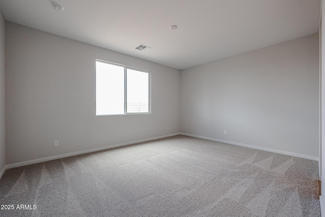 spare room featuring carpet floors, baseboards, and visible vents