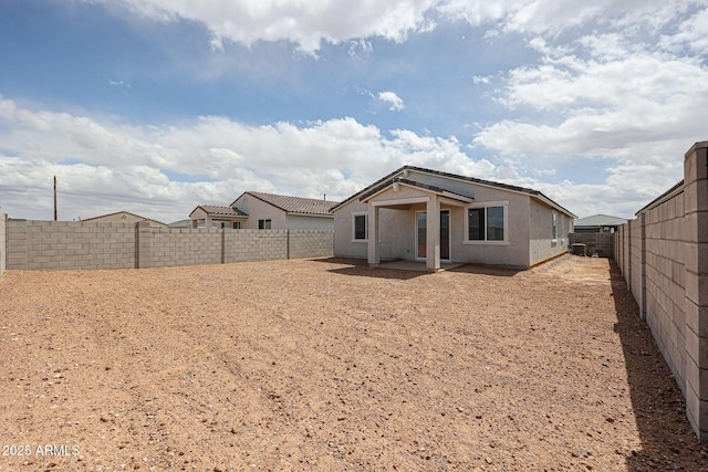 rear view of house with a fenced backyard, a patio area, and stucco siding