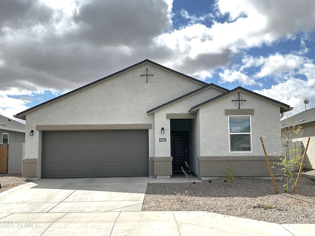 ranch-style house featuring a garage, driveway, and stucco siding