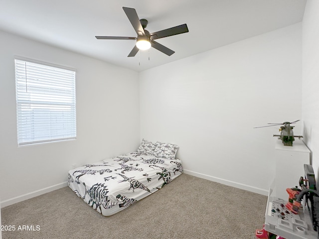 bedroom with a ceiling fan, baseboards, and carpet flooring