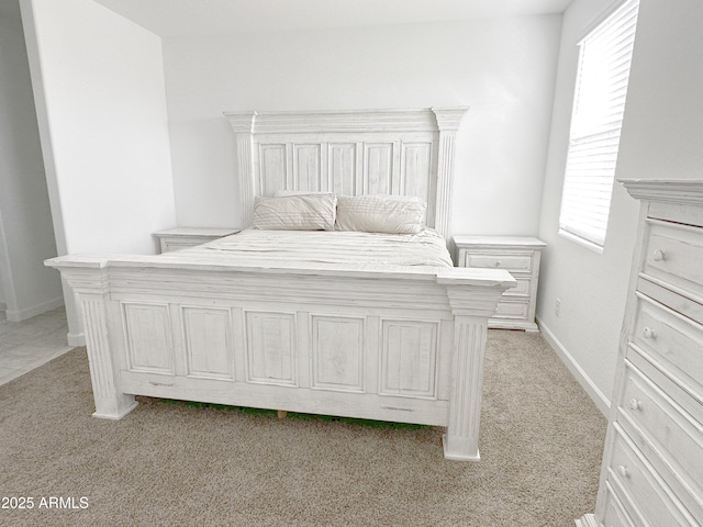 bedroom featuring light colored carpet and baseboards