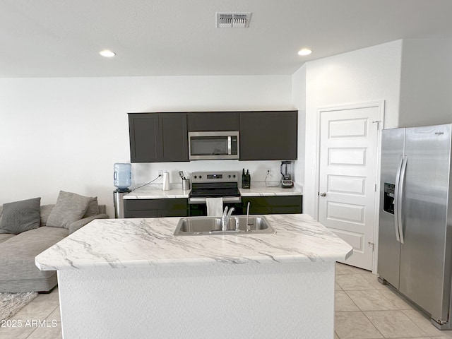 kitchen featuring visible vents, appliances with stainless steel finishes, a kitchen island with sink, a sink, and recessed lighting