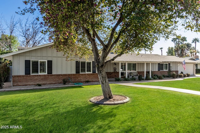 ranch-style house with an attached garage, brick siding, a front lawn, and board and batten siding
