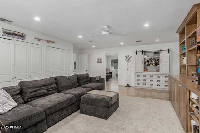 living room with ceiling fan, visible vents, and recessed lighting