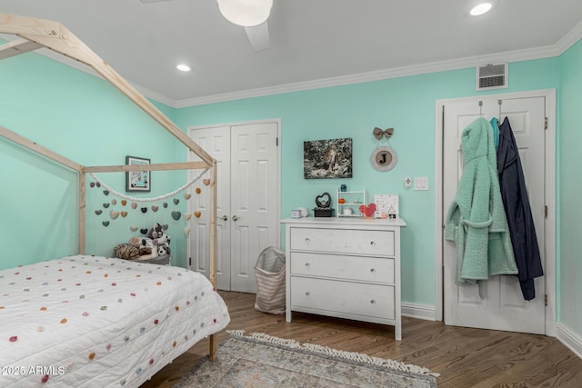 bedroom with a closet, visible vents, ornamental molding, wood finished floors, and recessed lighting