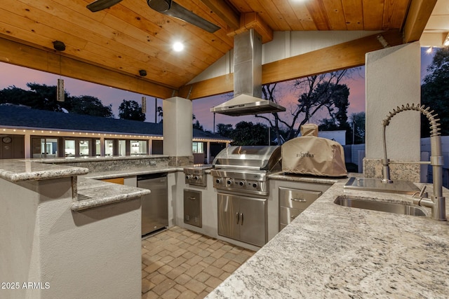 patio terrace at dusk featuring a grill, exterior kitchen, and a sink