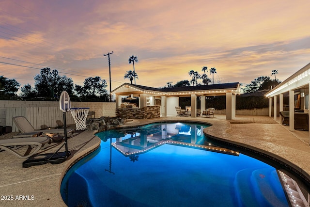 view of pool featuring a fenced backyard, outdoor dry bar, a patio, and a fenced in pool