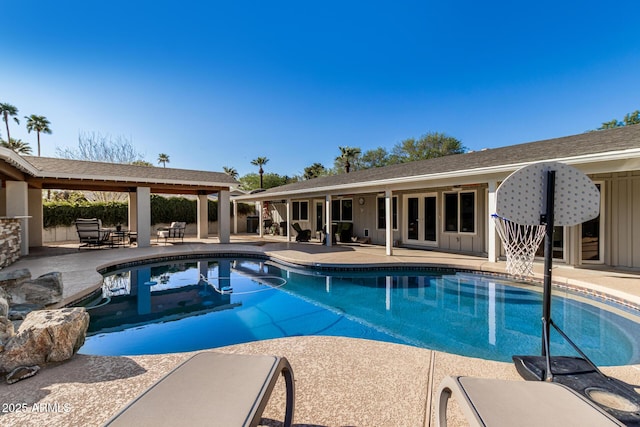 outdoor pool featuring french doors and a patio area