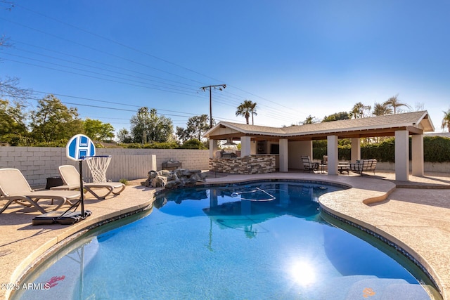 view of pool with a fenced backyard, a fenced in pool, outdoor dry bar, and a patio