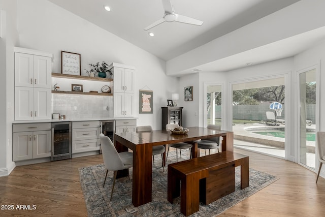 dining room featuring wood finished floors, indoor bar, and beverage cooler