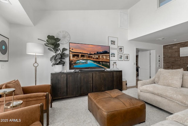 carpeted living room with baseboards, visible vents, and a high ceiling