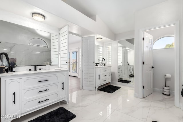 bathroom with lofted ceiling and vanity