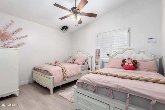 bedroom featuring light wood-type flooring, vaulted ceiling, and ceiling fan