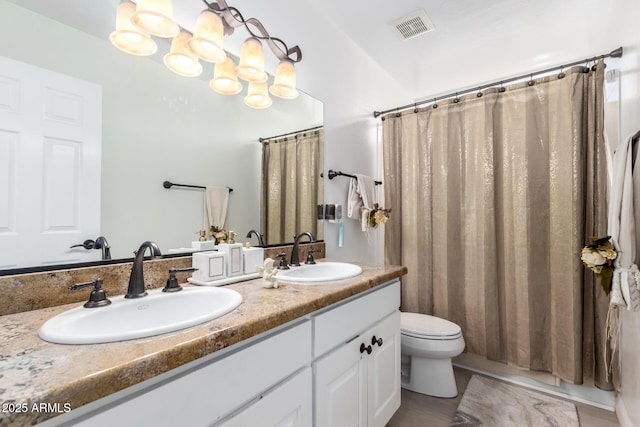 bathroom with toilet, vanity, a notable chandelier, and tile patterned flooring