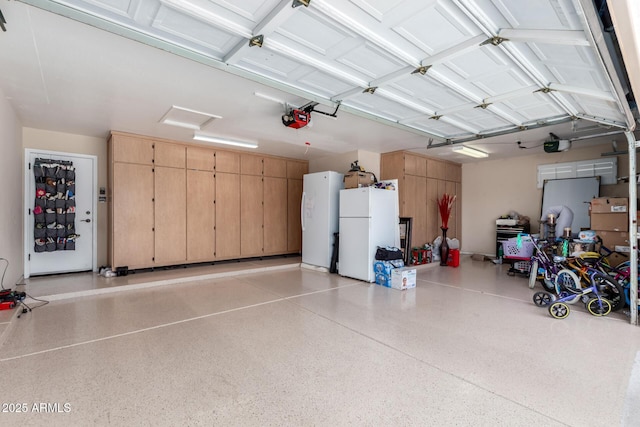 garage featuring white refrigerator and a garage door opener