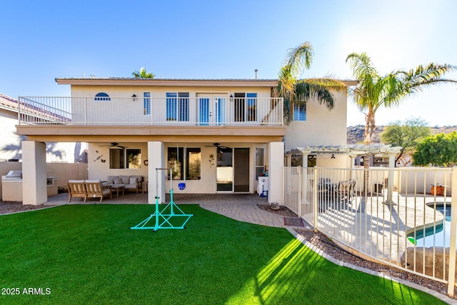 rear view of property with an outdoor living space, a patio area, ceiling fan, and a balcony