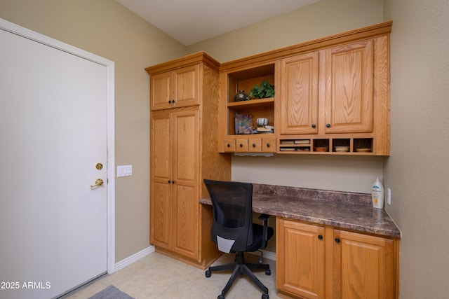 home office featuring light tile patterned flooring and built in desk