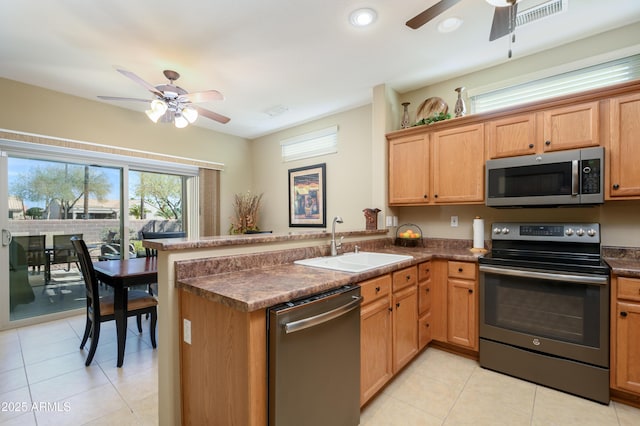 kitchen with sink, kitchen peninsula, ceiling fan, and appliances with stainless steel finishes