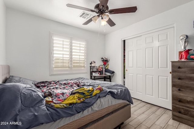 bedroom with ceiling fan, a closet, and light wood-type flooring