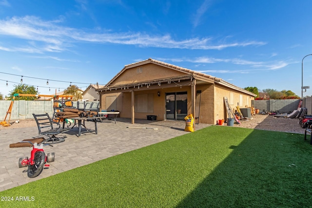 rear view of property featuring a patio area and a yard