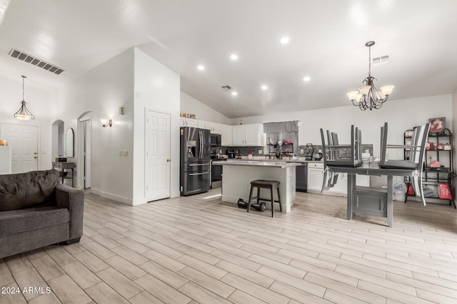 kitchen featuring a kitchen island, decorative light fixtures, a breakfast bar, white cabinets, and appliances with stainless steel finishes