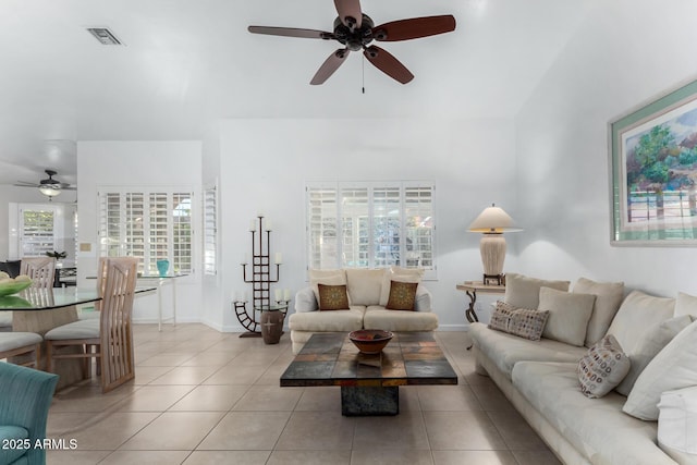 living room featuring tile patterned flooring, visible vents, and baseboards