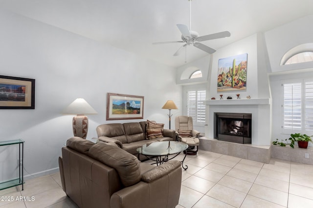 living area with light tile patterned floors, plenty of natural light, a tile fireplace, and a ceiling fan