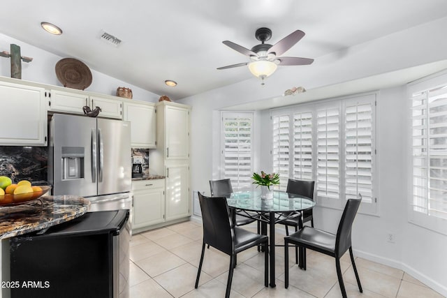 dining space with a wealth of natural light, lofted ceiling, visible vents, and light tile patterned floors