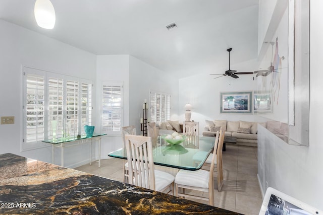 unfurnished dining area with lofted ceiling, light tile patterned floors, ceiling fan, and visible vents