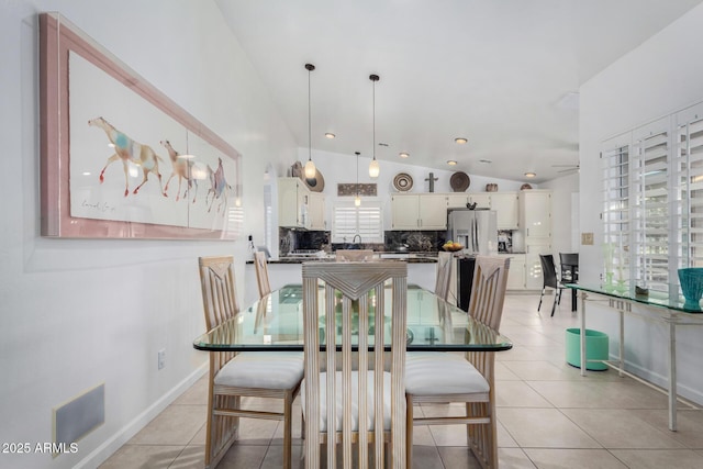 dining space featuring a ceiling fan, vaulted ceiling, and light tile patterned floors