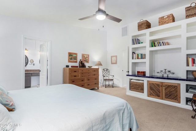 carpeted bedroom featuring visible vents and ensuite bath