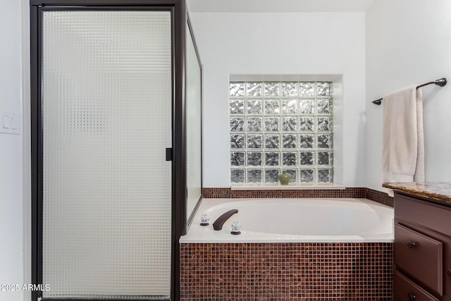 bathroom with a garden tub and vanity