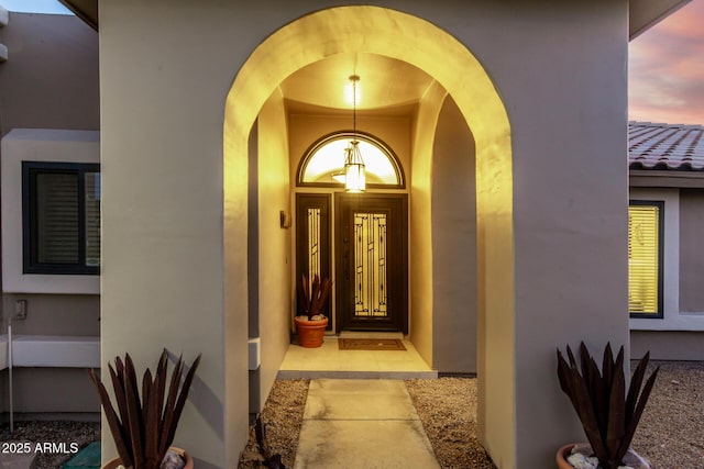 property entrance with a tiled roof and stucco siding