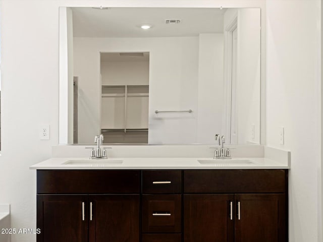 full bathroom with double vanity, visible vents, and a sink