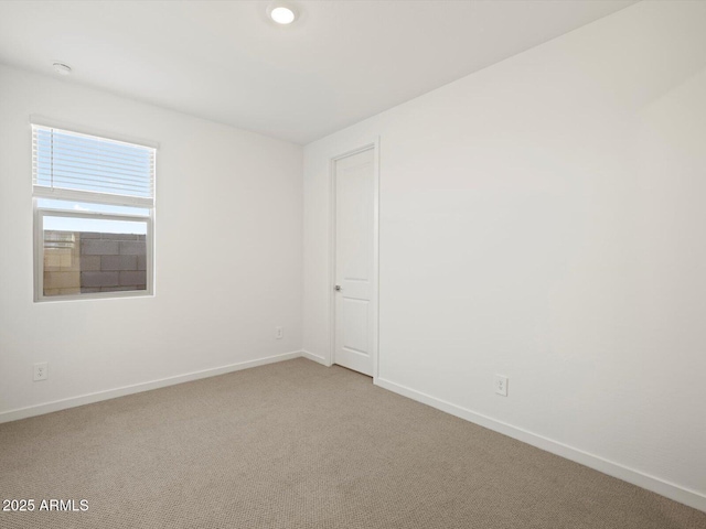 unfurnished room featuring carpet and baseboards