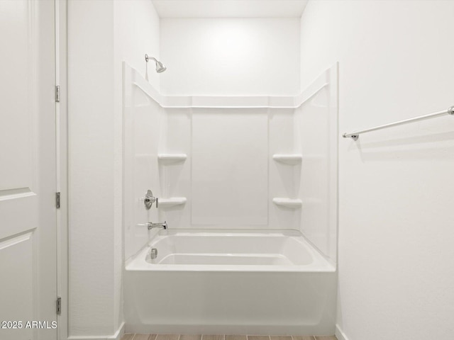 bathroom with shower / bathing tub combination and baseboards