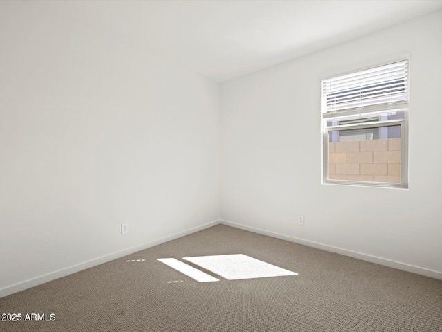 spare room with carpet and baseboards