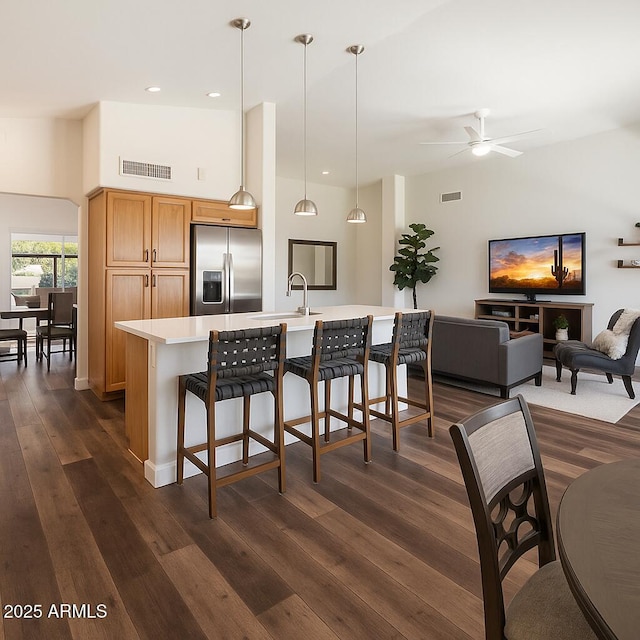 15020 N 54th Pl, Scottsdale, AZ 85254 - kitchen featuring stainless steel refrigerator with ice dispenser, dark wood-type flooring, light countertops, ceiling fan, and a breakfast bar