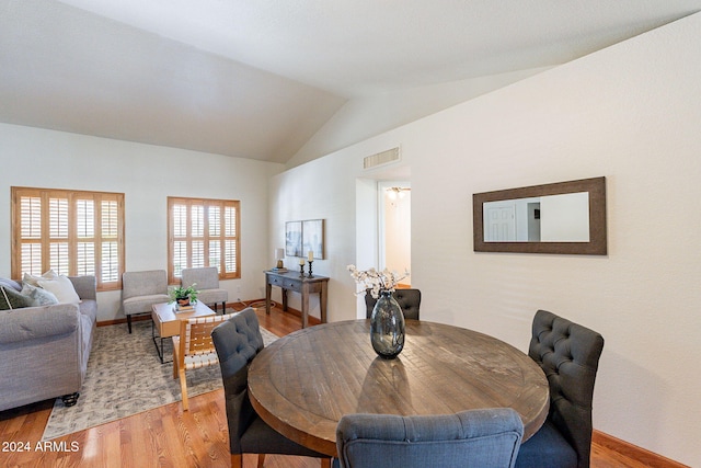 dining space featuring light wood-type flooring and lofted ceiling