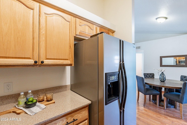 kitchen featuring stainless steel fridge, light hardwood / wood-style flooring, and light brown cabinets