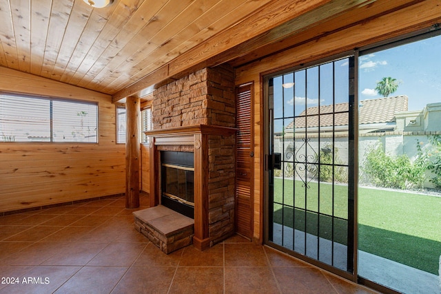 unfurnished living room with a fireplace, tile patterned flooring, wooden walls, and wood ceiling