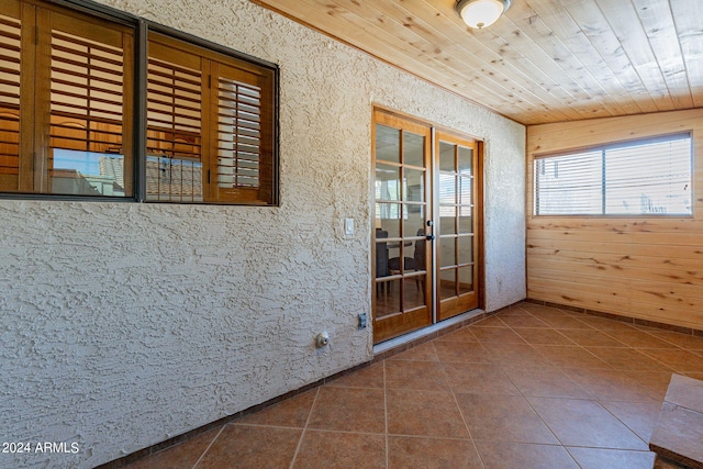 interior space featuring tile patterned flooring and wooden ceiling