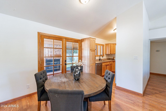 dining room featuring light hardwood / wood-style floors, lofted ceiling, sink, and french doors